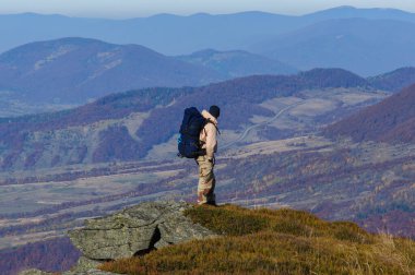 Bir erkek turist, Ukrayna Karpatları 'nda sonbahar kayalık patika boyunca yürüyor.