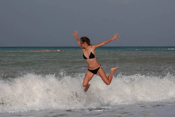 Femeie Zveltă Într Costum Baie Negru Sare Peste Valurile Mare — Fotografie, imagine de stoc