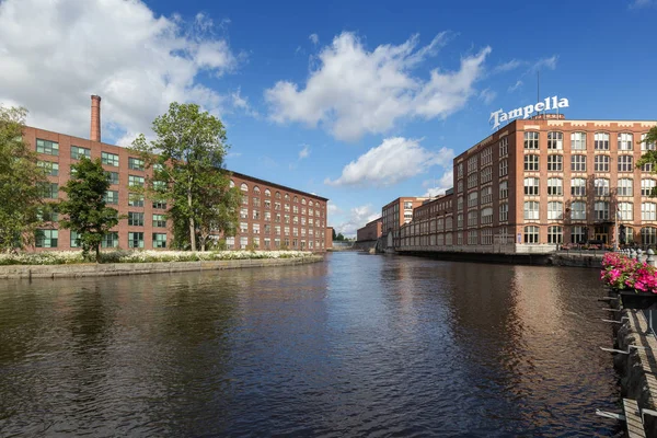 Old red brick industrial buildings along the Tammerkoski rapids in downtown Tampere, Finland on a sunny day. Tampella was an industrial company operating there but nowadays it\'s a district of the same name.