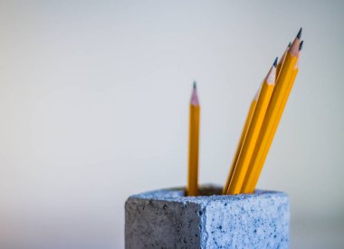 Sarı ahşap kalemler ve gri çimento-beton sanayi küp gölgeler ile