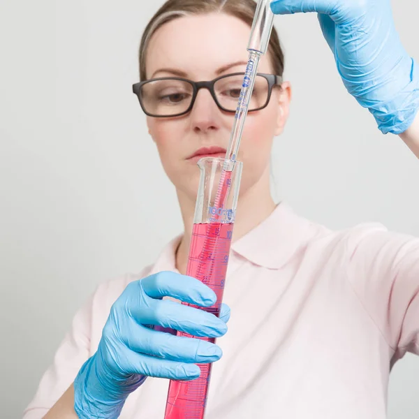 bir test tüpünde bir laboratuvar ile kadın bilim adamı