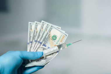 Doktorun elini medikal ürünler ile para tutuyor