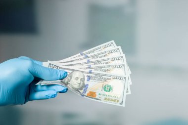 Doktorun elini medikal ürünler ile para tutuyor