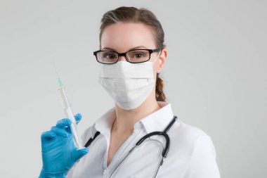 kadın doktor el ve stetoskop ve tıbbi yüz maskesi şırınga