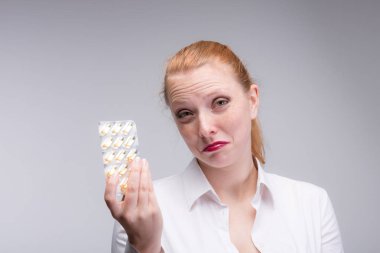 onun elinde haplarla endişeli kadın