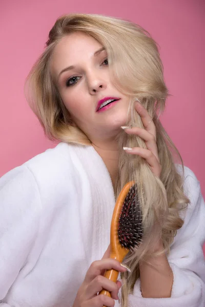 Mladá Blond Žena Kartáče Vlasy Před Růžové Pozadí — Stock fotografie