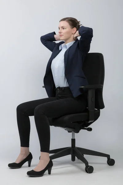 Business woman is doing exercises on office chair