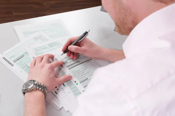 Junger Mann Füllt Schreibtisch Eine Steuererklärung Aus — Stockfoto