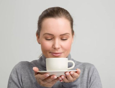 Bir fincan taze kahve onun elinde olan güzel kadın