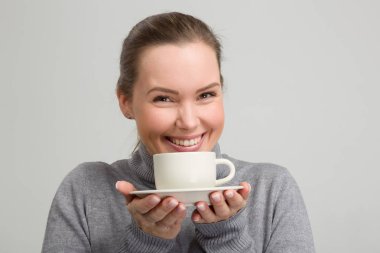 Bir fincan taze kahve onun elinde olan güzel kadın