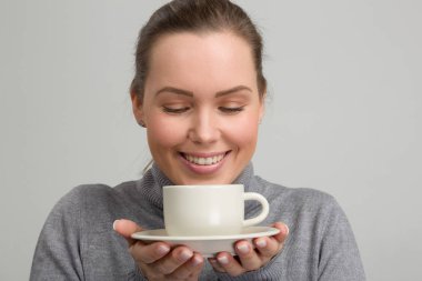 Bir fincan taze kahve onun elinde olan güzel kadın