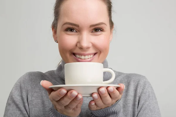 Young beautiful woman with a cup of fresh coffee in her hand