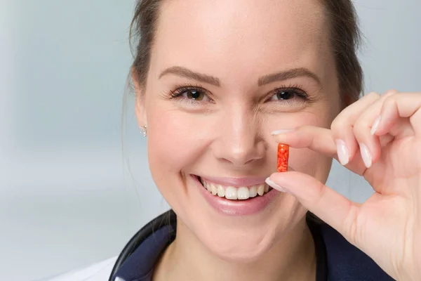 close up of a young female doctor presenting a pill