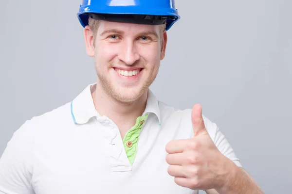 Jovem Engenheiro Sorridente Com Chapéu Duro Azul Mostra Polegar Para — Fotografia de Stock