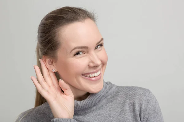 Joven mujer sonriente está escuchando — Foto de Stock