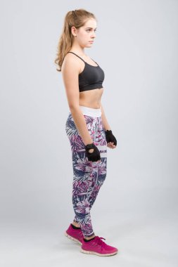 genç kadın bir fitness salonunda germe egzersizleri yapıyor