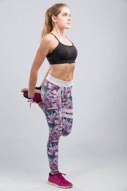 genç kadın bir fitness salonunda germe egzersizleri yapıyor