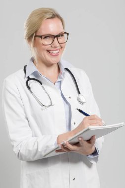 Steteskoplu, doktor dostu genç bayan doktor anestezi için notlar alıyor.