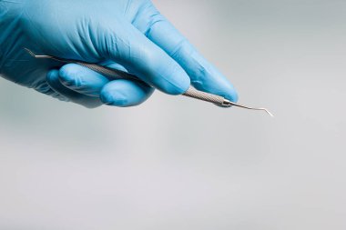 Diş hekiminin eli mavi eldivenli, diş fırçasıyla.