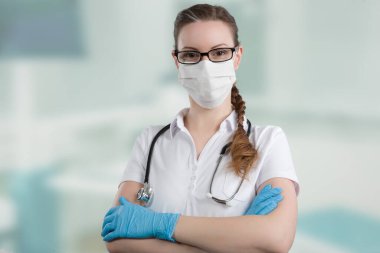 Korunmak için tıbbi maskeli ve tıbbi eldivenli kadın doktor ya da hemşire