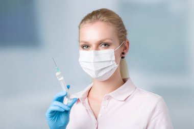 Kadın doktor ya da hemşire şırıngayla ilgileniyor. 