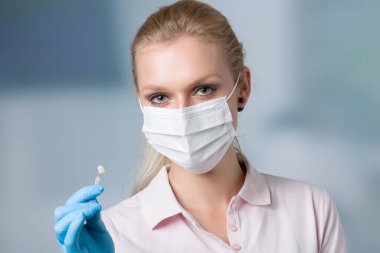 Diş maskesi takan dişçi asistanı / kadın diş hekimi