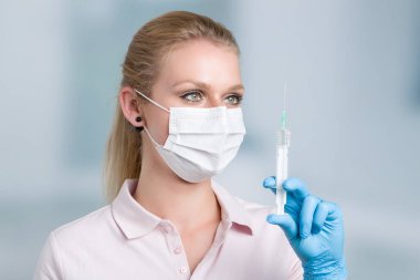 Kadın doktor ya da hemşire şırıngayla ilgileniyor. 