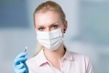 Diş maskesi takan dişçi asistanı / kadın diş hekimi