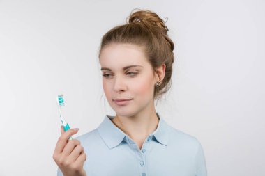 Dişi genç diş fırçasını gösteriyor