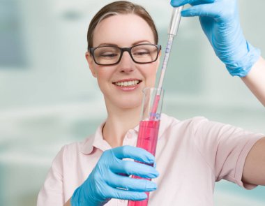 Renkli bir sıvı suyu içeren test tüpü olan bir kadın bilim adamı.