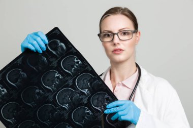 Kadın doktor röntgen taramasına bakıyor.