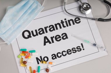 Doktorun elinde tıbbi eldiven var. Önünde karantina işareti var.