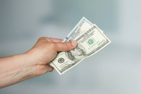 men 's hand with a bunch of dollar bills