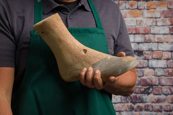 close up of hands of orthopedic shoemaker presenting an individu