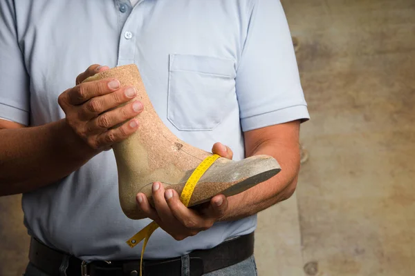 Close up of hands of an orthopedic shoemaker presenting an indiv