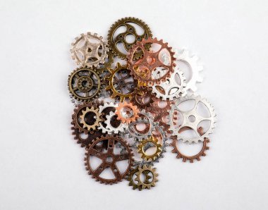 Farklı boyutlarda ve beyaz bir arka plan üzerinde renkli dişliler