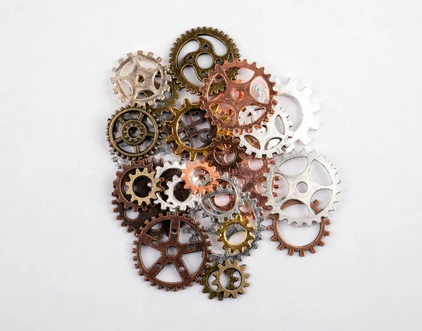 Farklı boyutlarda ve beyaz bir arka plan üzerinde renkli dişliler