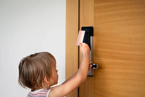 Kleiner Junge versucht Türen mit Kartenschloss im Hotel zu öffnen — Stockfoto