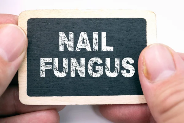 Nail fungus, text on blackboard. Fungal infection on nails hand, finger with onychomycosis, damage on human hand