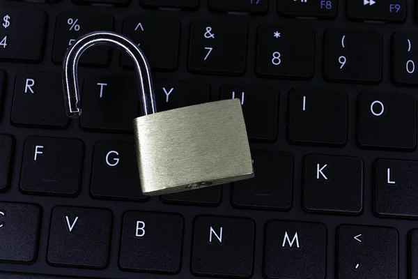 Unlocked padlock on computer keyboard