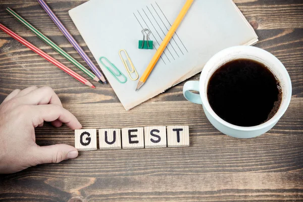 Guest. Wooden letters on the office desk