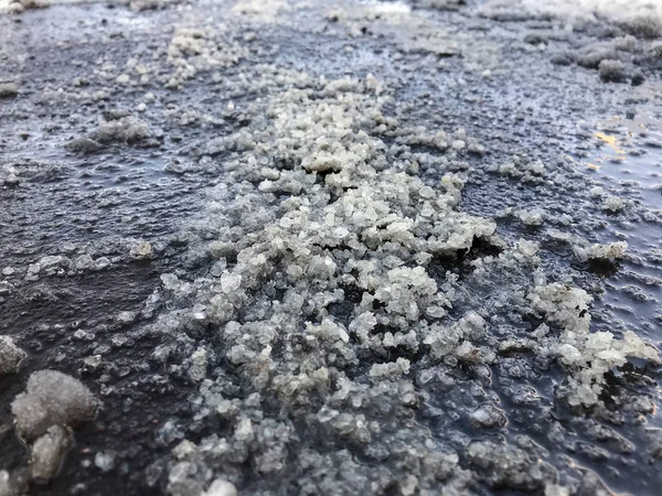 Salt spilled on the pavement. Winter season