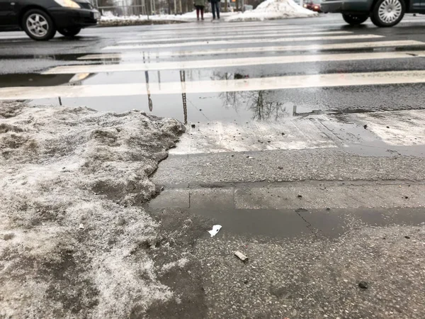 Spring, snow melting. Dirty, wet and slippery pedestrian walkways