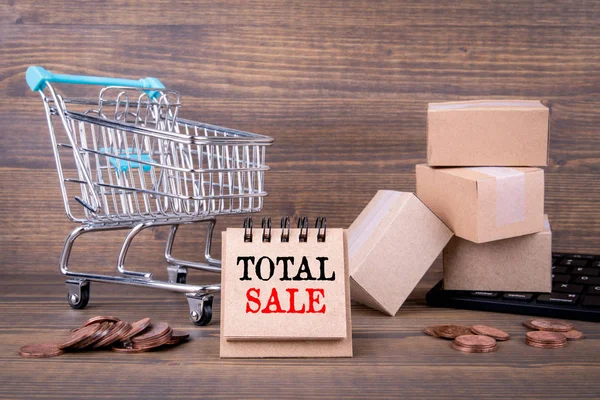 Total Sale concept. Paper boxes, shopping cart and computer keyboard on wooden background — Stock Photo, Image