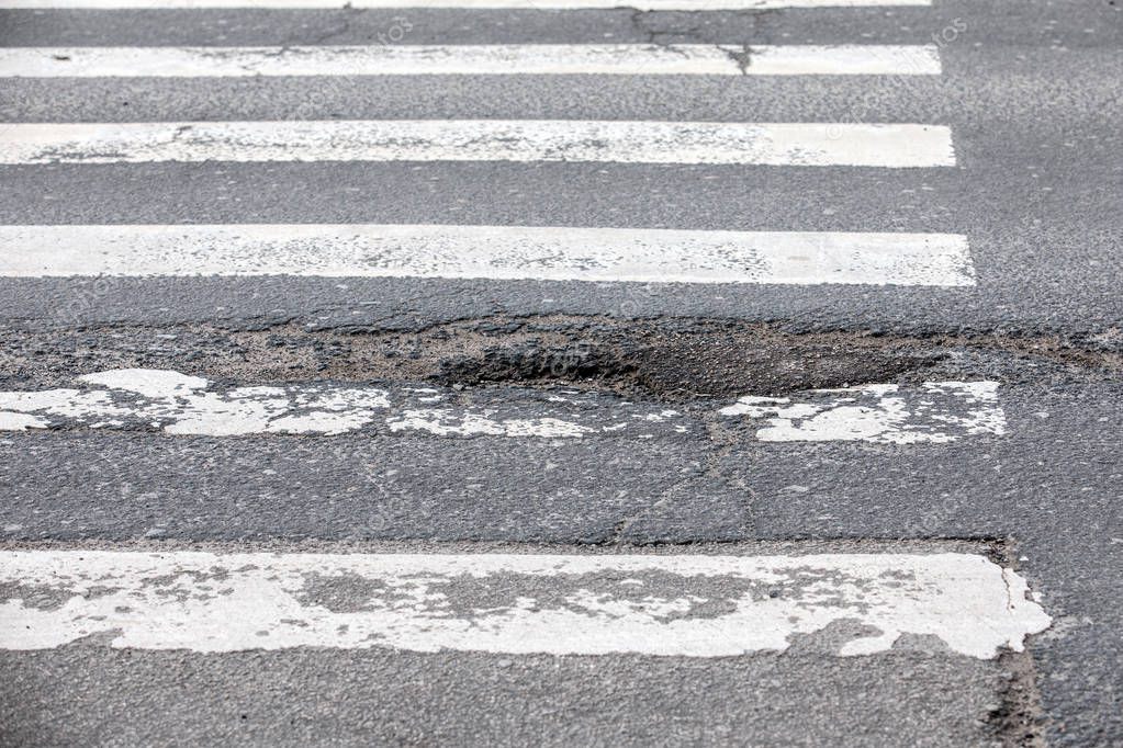 Damaged asphalt road with potholes