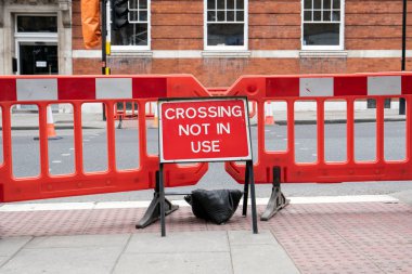 İngiltere'de bir şehir caddesinde kullanımda olmayan yol tabelasını geçmek
