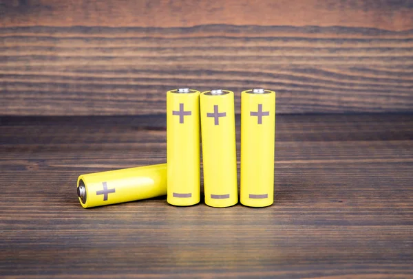 Baterie o rozmiarze AA na drewnianym tle — Zdjęcie stockowe