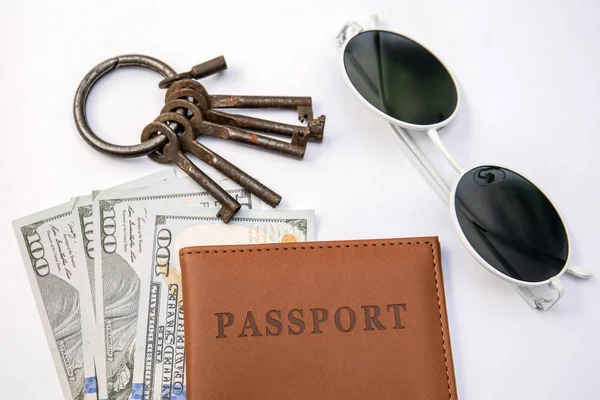 Ένα μάτσο διαφορετικά κλειδιά, διαβατήριο και χρήματα σε λευκό φόντο — Φωτογραφία Αρχείου