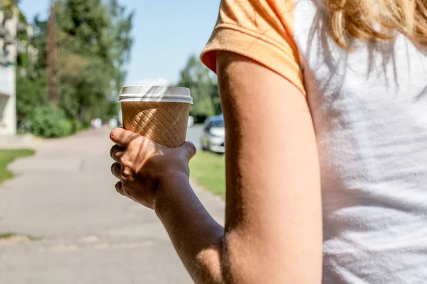 Holding takeaway coffee cup on the street