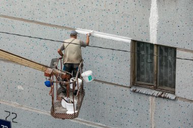 İşçi blok ev cephe yeniler. Macun ile dış duvarın sıva sızdırmazlık muhatap